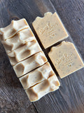 Image shows a group of yellow soaps with poppyseeds inside.