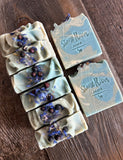 Image shows a green, blue and white soap with botanicals on top