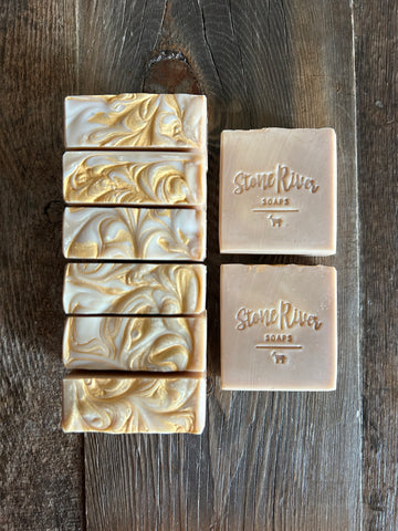 Image shows a group of tan soaps with gold mica swirls on top