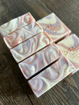Image shows a group of pink, purple, and white soaps with a swirl design.