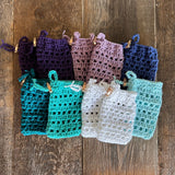 Image shows a group of hand knit cotton thread soap pouches with fasteners 