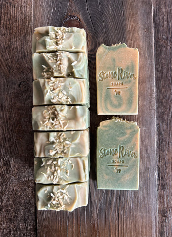 Image shows a group of yellow and green soaps topped with yellow flower petals.