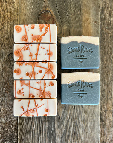 Image shows a group of black and white soaps with copper dots and swirls on top