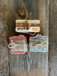 Image shows individually wrapped soaps tied in groups of three.