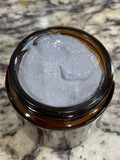 Open jar showing charcoal facial wash